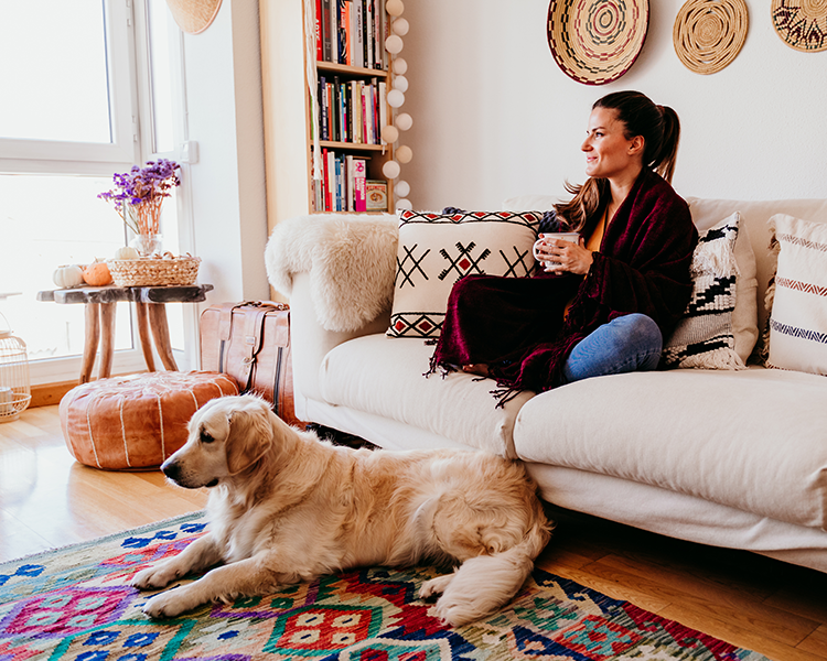 Vrouw zit met haar hond te genieten van haar kleine ruimte die door een interieurstylist is ingericht